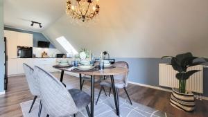 mesa de comedor con sillas y lámpara de araña en JOOYFUL STAYS Apartments, en Kevelaer