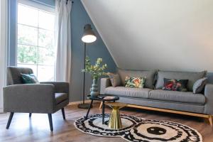 sala de estar con sofá y silla en JOOYFUL STAYS Apartments, en Kevelaer