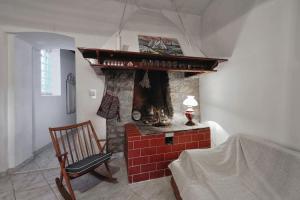 een woonkamer met een stenen open haard met een stoel bij Apartment 'Dan' in Zlarin