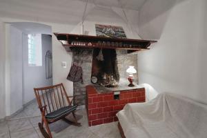 a living room with a brick fireplace with a chair at Apartment 'Dan' in Zlarin