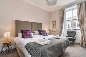 een slaapkamer met een groot bed en handdoeken bij 10 Murray Park in St Andrews