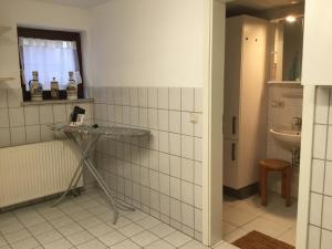 Baño de azulejos blancos con lavabo y espejo en Ferienhaus Barth, en Bad Salzungen