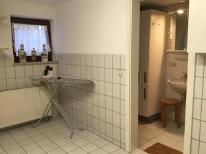 a white tiled bathroom with a sink and a mirror at Ferienhaus Barth in Bad Salzungen +50 photos