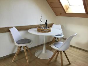 una mesa blanca con 2 sillas y una botella de vino en Ferienhaus Barth, en Bad Salzungen