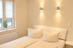 um quarto com duas almofadas brancas numa cama em Quartier Spreestraße Apartment 3 em Burg
