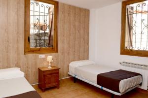 a bedroom with two beds and two windows at La Coma in Taüll