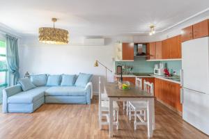 a living room with a blue couch and a kitchen at Casa Juanita in Playa de San Juan