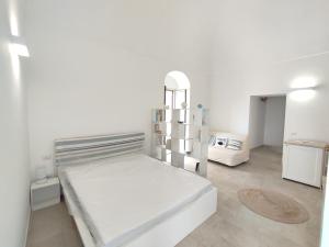 Elegante Monolocale + Soppalco in Centro e Vicino al Mare - DiscoverGargano Com في فييستي: غرفة نوم مع سرير أبيض كبير في غرفة