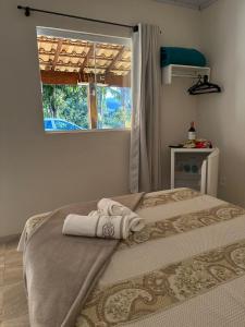 林多亞的住宿－Pousada Recanto dos Pássaros，一间卧室配有带毛巾的床