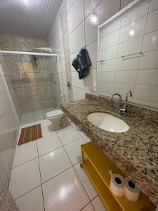 a bathroom with a sink and a shower and a toilet at Pousada Recanto dos Pássaros in Lindóia