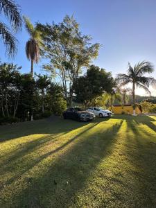 dos coches aparcados en un patio con palmeras en Pousada Recanto dos Pássaros, en Lindóia