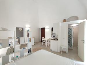 Elegante Monolocale + Soppalco in Centro e Vicino al Mare - DiscoverGargano Com في فييستي: شقة بيضاء فيها مطبخ وغرفة طعام