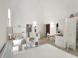 Elegante Monolocale + Soppalco in Centro e Vicino al Mare - DiscoverGargano Com في فييستي: شقة بيضاء فيها مطبخ وغرفة معيشة