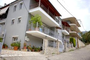 een wit gebouw met balkons en planten erop bij Το σπίτι της Άρτεμης in Nafpaktos