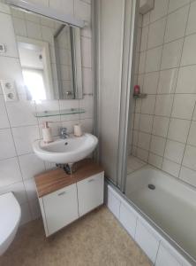 a white bathroom with a sink and a shower at Gasthaus L&A Kunz in Dümpelfeld