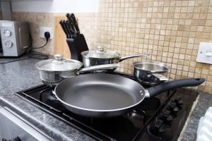 a stove with pots and pans on top of it at Holiday House for 7 Guests, Free Wi-Fi & Self Check-In Explore Newport in Newport
