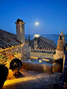 een huis met uitzicht op de oceaan in de nacht bij Maison d’Art Monemvasia in Monemvasia