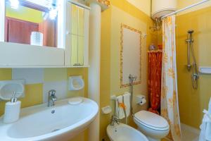 łazienka z umywalką, toaletą i lustrem w obiekcie La casa Arancione w mieście Avola +18 zdjęć