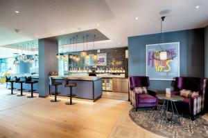 eine Bar mit Hockern und einer Theke in einem Zimmer in der Unterkunft Premier Inn Berlin Airport in Berlin