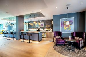 a bar with stools and a counter in a room at Premier Inn Berlin Airport in Berlin