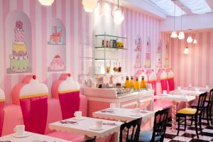a restaurant with pink walls and tables and chairs at Vice Versa in Paris