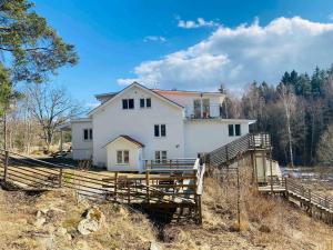 Bjurviks Villa - Flat 2 في Flen: منزل أبيض على تلة مع سياج خشبي