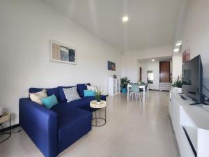 カレタ・デ・フステにあるPura Vida Luxury Home Sea Viewの青いソファとテレビのあるリビングルーム