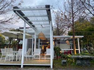 a white pergola with white chairs and tables at 好和院景 How Has in Chishang