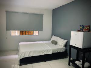 Habitación pequeña con cama y ventana en Hotel Los Mangos, en San Luis