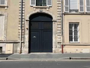 una puerta negra en el lateral de un edificio en COSY T3 Centre Reims/Pkg Privé, en Reims