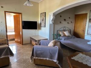 een woonkamer met 2 bedden en een bank bij Gavrilis Apartments in Nénita