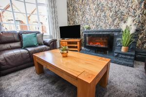 a living room with a coffee table and a fireplace at Stylish, spacious 3 bed house. Sleeps 7 in Lincoln