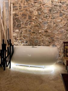 a bath tub in a room with a stone wall at LIVING IN A CAVE UNDER ACROPOLIS in Athens