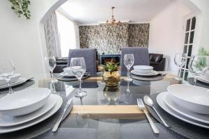 a dining room with a table with plates and glasses at Stylish, spacious 3 bed house. Sleeps 7 in Lincoln