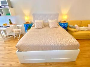 a bed in a living room with a couch and a bed at Appartamento Alice Smart in Bardolino