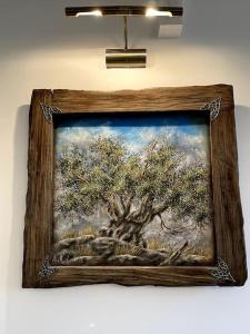 a framed picture of a tree on a wall at LIVING IN A CAVE UNDER ACROPOLIS in Athens