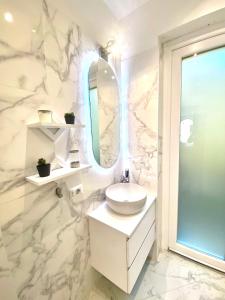 a white bathroom with a sink and a mirror at Appartamento Alice Smart in Bardolino +20 photos