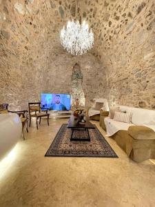 a living room with a couch and a chandelier at LIVING IN A CAVE UNDER ACROPOLIS in Athens