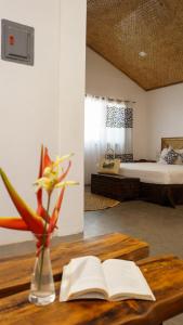 a room with a table with an open book and a bed at La Colonial Resort in El Nido