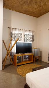 a living room with a television and a table at La Colonial Resort in El Nido