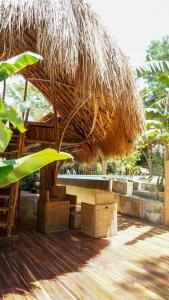 a large straw hut with chairs and a table at La Colonial Resort - Wellness Access Included in El Nido