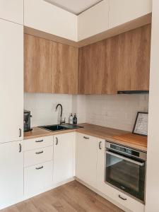 eine Küche mit weißen Schränken und einer Spüle in der Unterkunft Vitosha View Apartment & Free Parking in Sofia