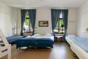 a bedroom with two beds and two windows at Nicolai B&B in Lidköping