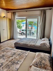 two beds in a room with a view of the ocean at Apartmani Branko Vojnovic in Omiš