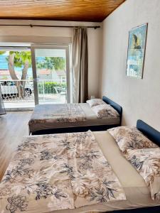 two beds in a room with a balcony at Apartmani Branko Vojnovic in Omiš