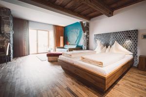 ein großes Schlafzimmer mit 2 Betten und einem Sofa in der Unterkunft Hotel Krallerhof in Leogang