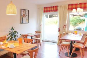 a dining room with tables and chairs and a window at Pension An der Kamske, DZ 4 in Lübbenau
