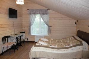 a bedroom with a bed and a window at Guest House U Pruda in Kostroma