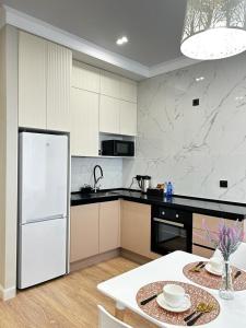 uma cozinha com um frigorífico branco e uma mesa em Talan life aparts em Atyrau