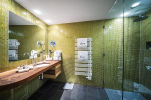 ein Bad mit einem Waschbecken und einer Dusche in der Unterkunft Hotel Krallerhof in Leogang